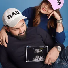 Let's have some fun with your announcement! Using props like these 'MOM' and 'DAD' hats along with your sonogram photo adds a playful and personal touch to your pregnancy photoshoot. It’s a cute way to share your joy with the world.