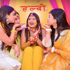 The Haldi ceremony is all about fun and family. We focus on capturing candid moments of joy, like this shot of the bride's friends playfully applying turmeric paste, a cherished memory from pre-wedding festivities.