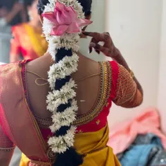 A stunning view of a traditional floral braid for Dr. Sushmita's Muhurtham. The combination of fresh jasmine and a beautiful pink lotus creates a unique and elegant statement.