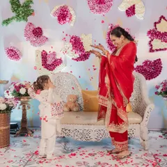 A sweet moment between the mom-to-be and a little one, showering each other with flower petals. The backdrop features lotuses and birds made from real flowers.