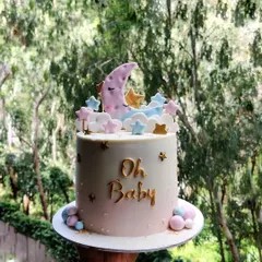 This "Oh Baby" cake was a special one, as I made it to announce my own little one on the way! The design features a sleepy moon nestled in pastel clouds and stars.