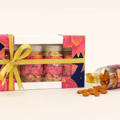 A taste of the festive season. This Diwali hamper features jars of premium almonds and cashews, presented in a vibrant box with a lotus-themed design and tied with a golden ribbon.