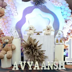 A close-up of the main cake table area for the modern teddy bear party, showing the fluted pedestal and light-up name sign.