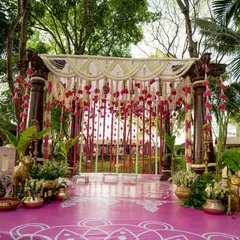 This is the stage where forever begins. The mandap is adorned with traditional brass props, banana leaves, and rangoli-patterned flooring, all under a canopy of fresh flowers, ready for the sacred wedding rituals.