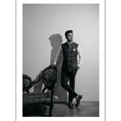 A classic black and white portrait of the groom-to-be. His confident pose next to an ornate chair, combined with dramatic lighting, gives this shot a sophisticated, old-world charm.