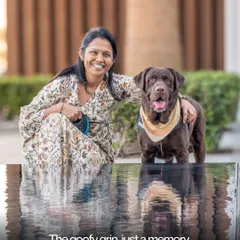 A beautiful portrait of a woman and her chocolate lab enjoying a moment by the water, their reflections adding a touch of magic to the scene.