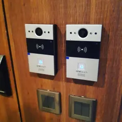 Here is an installation of two OneTouch video entry units on a wooden panel. This setup provides secure, app-based access control, allowing residents to see and speak with visitors before granting entry, all from their mobile phones.