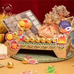 This festive Lohri hamper is arranged on a decorative stand and includes a box of assorted mithai, golden laddus, and potlis, all adorned with fun, colourful cutouts.
