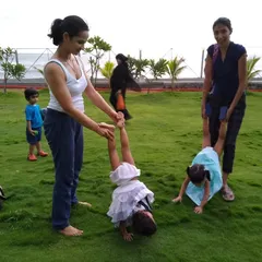 Children and parents playing together on the lush lawn. The success of a public space is measured by its use, and the immediate, joyful adoption of this park by the community is a testament to the project's impact.
