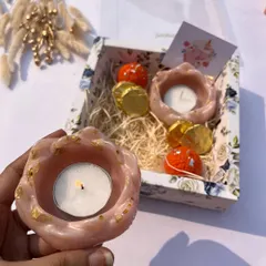 A cute and simple Diwali gift box with two floral resin tea light holders and chocolates.