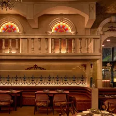 For the Latin American restaurant Los Cavos, we created a theatrical dining experience. A mezzanine balcony overlooks the main seating area, framed by classical arches and balustrades, evoking the feeling of a vibrant Cuban street scene. The warm, layered lighting and rich textures complete this immersive atmosphere.