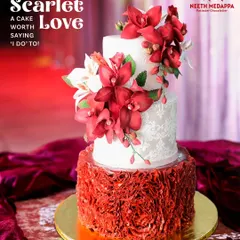For the couple wanting to make a bold statement, this scarlet and ivory wedding cake combines passion with elegance. The design features a dramatic cascade of handcrafted red sugar orchids against delicate lace-patterned tiers and a vibrant ruffled base, creating a look of pure romance.