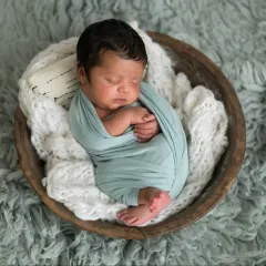 So tiny, so perfect, so loved. In my studio, I create a safe and warm environment for these classic newborn portraits. This little one, nestled peacefully in a wooden bowl, showcases the delicate art of posed newborn photography, where every detail is about celebrating this fleeting, sleepy stage.