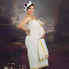 A beautiful solo portrait of a mom-to-be in a traditional Kasavu saree. Her joyful expression and the classic elegance of the attire make this a stunning celebration of motherhood and heritage.