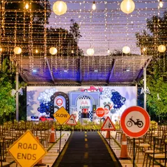 Vroom Vroom! For this race car party, I transformed the venue into a racetrack, complete with road signs, a starting line, and a canopy of string lights for a festive nighttime race feel.