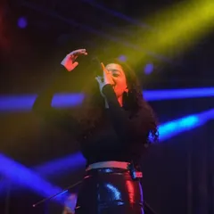 A female artist singing her heart out under colorful stage lights. College fests are a platform for diverse talents, and I make sure to capture them all.