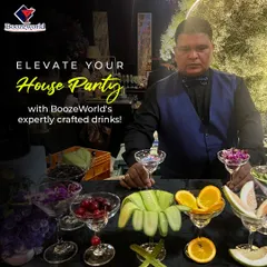 One of our expert bartenders is ready to elevate your house party. He stands behind a bar laden with fresh garnishes like cucumber, orange, and cherries, ready to craft custom drinks for your guests.