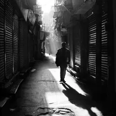 A man walks through a narrow, shuttered alley in Old Delhi, illuminated by a single shaft of morning light. This is the kind of poetic, high-contrast moment I am always searching for in my street photography.