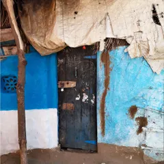 A rustic door on a bright blue wall, patched with tarpaulin. I find so much beauty in these makeshift, lived-in spaces.