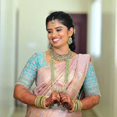 This happy client is wearing a beautiful peach and sky-blue silk saree. I designed the custom embroidered blouse to perfectly match the floral motifs in her saree.