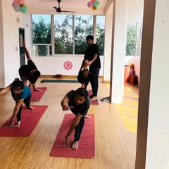 Students engaged in various standing poses like Parivrtta Trikonasana and Ardha Chandrasana, showcasing the dynamic nature of our group classes.