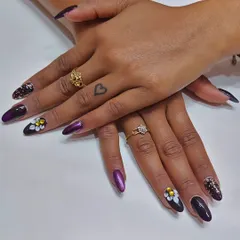 Another angle of the dark purple set, showing how the design looks across both hands. The placement of the 3D flowers and glitter nails creates a balanced and cohesive manicure.