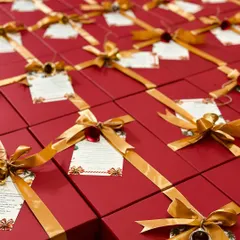 A sea of vibrant red gift boxes, each tied with a gold ribbon and a festive bell. This is part of a large corporate order for Christmas, ready to spread holiday cheer.