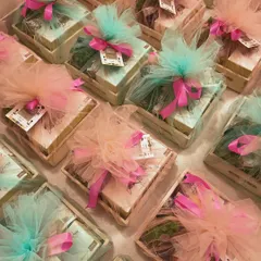 A beautiful array of pastel-themed hampers, each wrapped in soft tulle and tied with a vibrant pink ribbon. This showcases our flair for creating visually stunning and cohesive event gifts.
