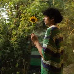 A guest finds a moment of quiet connection with a single sunflower, embodying the simple, heartfelt beauty we cultivate here.