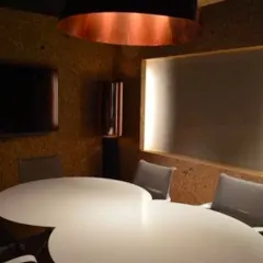 The conference room is designed for clarity and collaboration. A large, cloud-shaped table sits at the center, while a massive copper-lined pendant light provides warm, focused illumination.
