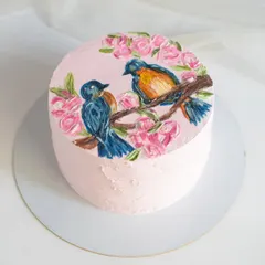A hand-painted cake featuring two beautiful birds perched on a branch surrounded by pink flowers. This was for a 50th birthday, and I love how the buttercream painting gives it an artistic, textured feel.