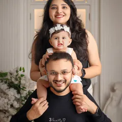 A classic and joyful family pose. Having the baby on dad's shoulders creates a fun, layered portrait that is full of happiness.