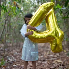 Happy fourth birthday. Holding up the number four balloon, this little girl is so proud of her new age. I love capturing these annual rituals that mark your child's growth.
