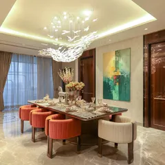 Dinner here always feels a little more special. The vibrant rust-colored chairs, the grand 12-foot marble table with brass inlay, and the bird-motif chandelier come together to create a space that invites you to pause and enjoy.
