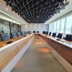 Conference rooms are where big ideas happen, so they shouldn't be boring. I designed this U-shaped boardroom with a dramatic, black acoustic ceiling that absorbs sound and adds incredible visual texture. The custom table and integrated lighting make it a highly functional and impressive space.