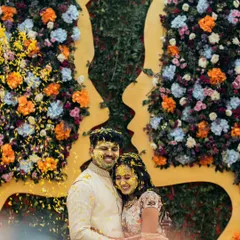 The pure, unadulterated joy of a Haldi ceremony. Anisha and Rishabh are showered with flower petals against a stunning floral backdrop, a candid moment that perfectly captures the vibrant energy and love surrounding them.