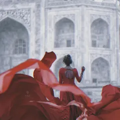 Making a statement against an iconic backdrop. The movement of the red fabric and the subject's pose create a powerful fashion-style portrait that stands out.