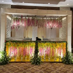 This bar front is heavily decorated with hanging wisteria and other florals, integrating it beautifully into the overall theme of the wedding. We ensure even functional areas like the bar become a part of the decor.