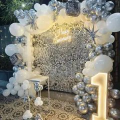 Another angle of the stunning silver and white first-anniversary decor, highlighting the disco ball and star-shaped balloon accents.