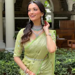 The joy of a bride who feels beautiful and confident. This shot captures the fresh, glowing makeup and the overall elegance of the pastel green saree and diamond jewelry.