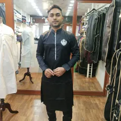 This client is seen during a fitting for his black custom kurta. The design features a modern zip placket and a subtle, elegant crest embroidery, demonstrating how we tailor even simple designs to your unique style.