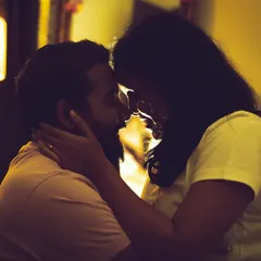 A silhouette of a couple about to kiss, with warm backlighting creating a romantic and tender mood. We use creative lighting techniques to capture emotion.