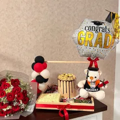 A perfect gift for a new graduate. This tray hamper includes a custom cake, a personalized teddy bear, a bouquet of red roses, and a "Congrats Grad" balloon.