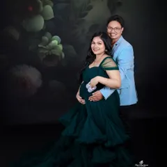 The dark green gown looks stunning in this couple's portrait, especially when paired with sweet props like these tiny baby shoes.