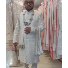 For the grooms, I offer elegant options like this pristine white embroidered sherwani. This rental comes as a complete set with a matching pagri, stole, and a layered pearl necklace.