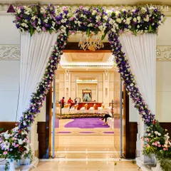 Another view of the elegant purple and white floral entrance arch, showcasing how it perfectly frames the view into the beautifully decorated reception hall.