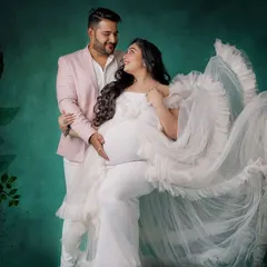 Creating a coordinated look for you and your partner is one of my favorite things to do. Here, my client wears a stunning white ruffled gown, perfectly complemented by a soft pink blazer for her partner, making their studio maternity session truly special.