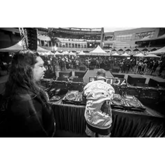 A black and white shot from behind the decks at the Artist Connect Dance Music Festival. You can feel the energy of the massive crowd waiting for the beat to drop.