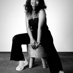 A full-body portrait in black and white can be incredibly powerful. This shot of a model in a simple black outfit and sneakers has a relaxed, modern, and confident feel, showcasing personality.
