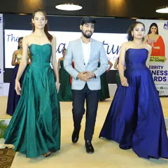 A moment from the finale of the Celebrity Business Awards fashion show. I am walking the ramp with models wearing my custom-designed strapless evening gowns in emerald green and royal blue.